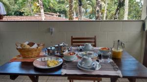 a wooden table with food on top of it at Pousada Canoeiro in Ubatuba