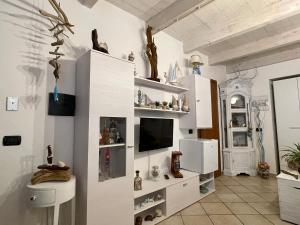 un soggiorno con armadi bianchi e TV di Il Posto Nascosto a Porto Torres