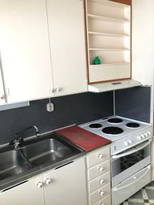 a kitchen with a sink and a stove at Fjällnära Stuga i Jämtland in Svenstavik