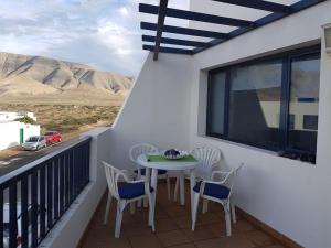 ein Tisch und Stühle auf einem Balkon mit Aussicht in der Unterkunft Apartamento El Coral in Famara