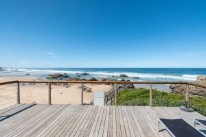 una terraza de madera con vistas a la playa en Picnic Rock Seaside Accommodation, en Keurboomstrand