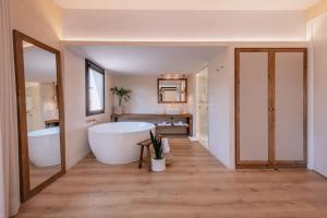 uma casa de banho com uma banheira grande e um lavatório em Hotel Palau Macelli em Castelló d'Empúries