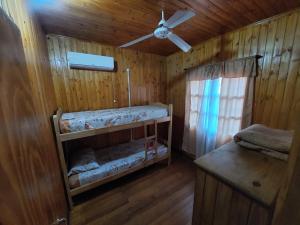 a room with two bunk beds and a ceiling fan at Morada Silvestre Iguazú in Puerto Iguazú