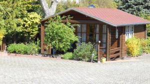 a small wooden cabin with a red roof at Pension Mittag in Heringsdorf