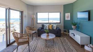 a living room with a couch and a table at Picnic Rock Seaside Accommodation in Keurboomstrand