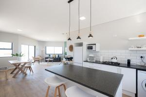 a kitchen and living room with a table and chairs at Picnic Rock Seaside Accommodation in Keurboomstrand