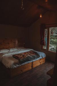 a bed in a room with a window at Enthralling Escapes Nature Stay and Trek in Manāli