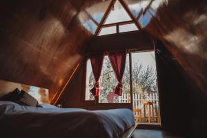 een slaapkamer met een raam en een bed in een kamer bij Enthralling Escapes Nature Stay and Trek in Manāli