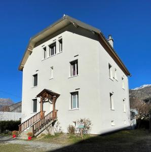 a large white building with a gambrel roof at Villa Lutel in Le Bourg-dʼOisans