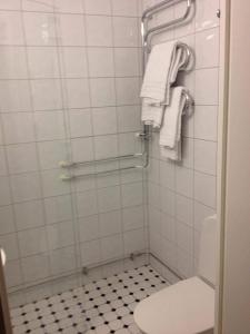 y baño con ducha, aseo y toallas. en Avanti Apartment Hotel en Estocolmo