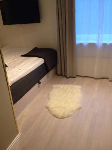 a bedroom with a bed and a white rug at Avanti Apartment Hotel in Stockholm