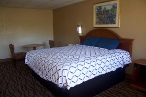 sypialnia z łóżkiem z niebiesko-białą kołdrą w obiekcie Express INN w mieście Norfolk