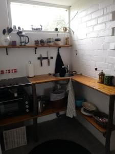cocina con estanterías de madera, fregadero y ventana en Keramikhuset 2 komma 0, smuk natur og hjemlig hygge en Horsens