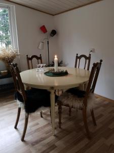 a dining room table with a candle and chairs at Keramikhuset 2 komma 0, smuk natur og hjemlig hygge in Horsens