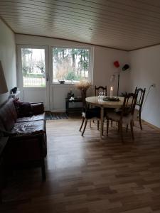 un soggiorno con tavolo e divano di Keramikhuset 2 komma 0, smuk natur og hjemlig hygge a Horsens
