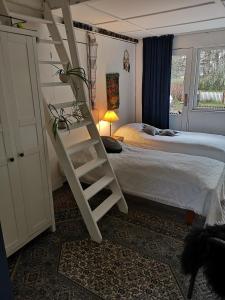 1 dormitorio con una escalera junto a la cama en Keramikhuset 2 komma 0, smuk natur og hjemlig hygge en Horsens