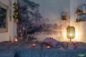 a bedroom with candles on a bed with a painting at Le Clos des Eucalyptus in Plan-de-la-Tour +65 photos