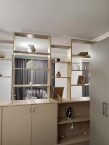 a room with white shelves and a desk with a window at Izmir Apartment in Baku