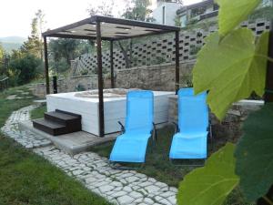 2 sedie blu sedute di fronte a una vasca idromassaggio di Il Poggetto Moon Light Home Stay ad Arezzo