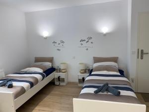 dos camas sentadas una al lado de la otra en un dormitorio en Home-Rose-Garden-Gästehaus kontaktloser Zugang, en Düsseldorf