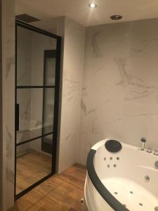 a bathroom with a white tub and a mirror at B&B Driel in Driel
