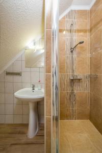 a bathroom with a sink and a shower at Füredi Apartman in Tiszafüred