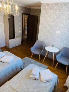 カズベギにあるGOLDEN STAR KAZBEGIのベッド2台、テーブル、椅子が備わる客室です。