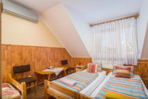a room with two beds and a table at Füredi Apartman in Tiszafüred