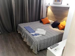 1 dormitorio con 1 cama con almohadas de color naranja y azul en Maspalomas Bungalow C I, en Maspalomas