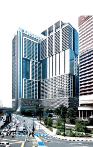 duży budynek z samochodami na ruchliwej ulicy miejskiej w obiekcie Platinum Suites Klcc by Signature Apartment w Kuala Lumpur