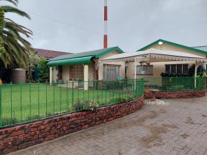 a house with a fence in front of it at Floret Cottage in Welkom