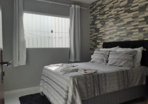 um quarto com uma cama e uma parede de tijolos em Casa Serena Jacumã em Jacumã