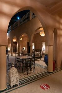 a patio with tables and chairs in a building at Maison Hassan Merzouga in Merzouga