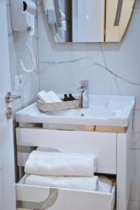 bagno con lavandino, specchio e asciugamani di Hotel Jurgen a Rinas