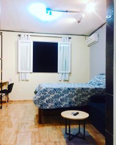 a bedroom with a bed and a couch and a table at Loft/kit estilo industrial encantador c/garagem pv in Belém