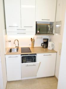 a white kitchen with a sink and a microwave at Kupferberg - helles und gemütliches Appartement in Uninähe in Mainz