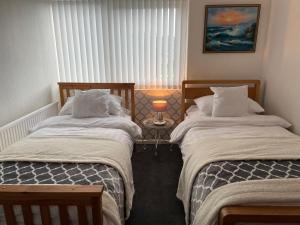 two beds sitting next to each other in a bedroom at Hoffman Hideaway in Buxton