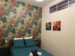 a bedroom with a bed with a colorful wallpaper at Le Gîte de Lancelot avec balnéo City Center in Sens