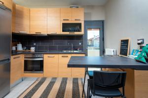 a kitchen with wooden cabinets and a black counter top at Το σπίτι δίπλα από το ποτάμι in Tríkala