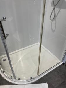 una doccia con porta in vetro in bagno di Hoffman Hideaway a Buxton
