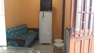a living room with a television on top of a refrigerator at Tartaruga Azul in Florianópolis