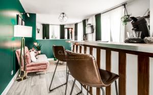 a living room with green and white walls and chairs at La Deauvillaise CLS Deauville in Deauville +16 photos