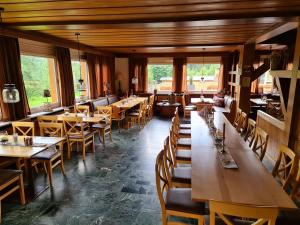restauracja z drewnianymi stołami, krzesłami i oknami w obiekcie Verena's Parkhotel w mieście Löffingen