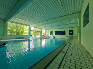 ein großer Pool mit einer Person, die darin schwimmt in der Unterkunft Verena's Parkhotel in Löffingen