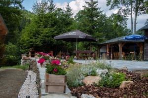 un jardín con sombrillas y flores y un edificio en Chata Myšák, en Malá Morávka