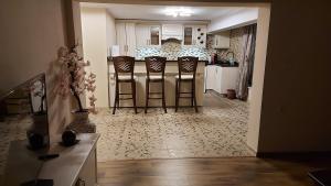 a kitchen with bar stools and a kitchen with white cabinets at Студио Лидия in Velingrad