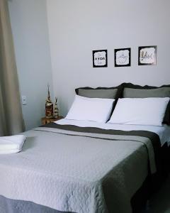 1 dormitorio con 1 cama grande con sábanas blancas en Pousada Alto Caparaó, en Caparaó Velho