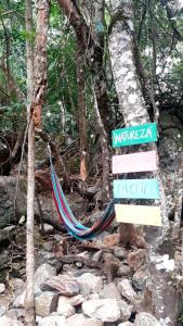 a sign in the middle of a trail in the woods at Pousada Alto Caparaó in Alto Caparao