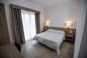 Hotel Nova Domus Aurelia في روما: غرفه فندقيه بسرير ونافذه