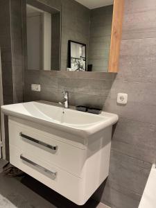 y baño con lavabo blanco y espejo. en Vakantie appartement Sunndays, en Valkenburg